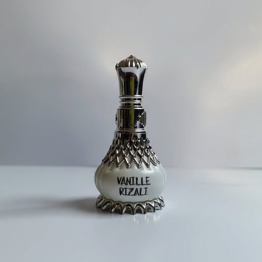 Perfume bottle with silver cap and decorative design on a white background