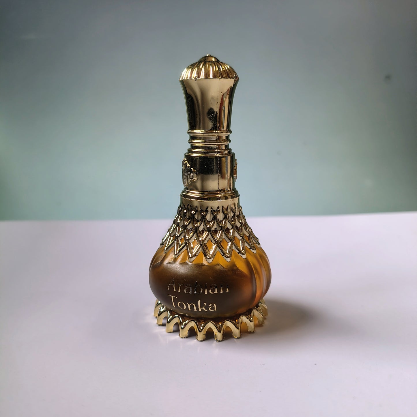 Decorative bottle with gold accents on a white surface and light gray background